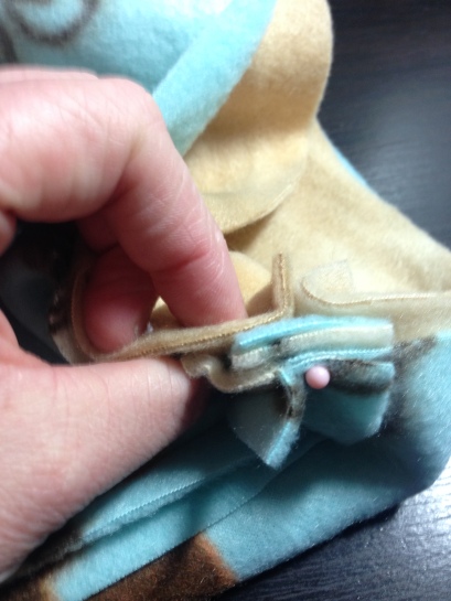 Pin the tab to hold it in place. Remember to always remove your pins before sewing over them!