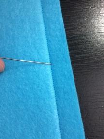 Typically a setting of 1.5mm to 1.8mm stitch length is best when using fleece. The stitches should be small enough that you cannot easily slip the tip of a straight pin underneath them. This applies to both top-stitch and inner seaming. With nice, tight stitches like these, you will eliminate the risk of an animal snagging it's nail on the thread and pulling loose the stitching.