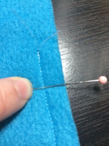 These stitches are too large. They do not sink neatly into the fleece, and I can easily slip a straight pin underneath them. You want your stitches to be even smaller than this for ultimate safety.